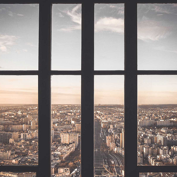 A view looking through a window over a modern city.
